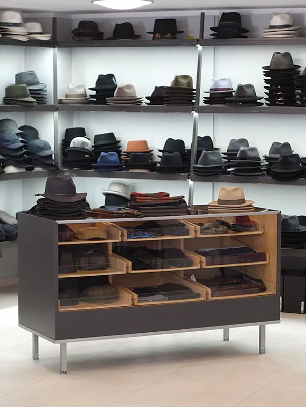 Ladeneinrichtung mit Vitrine und Regalen voller Hüte
